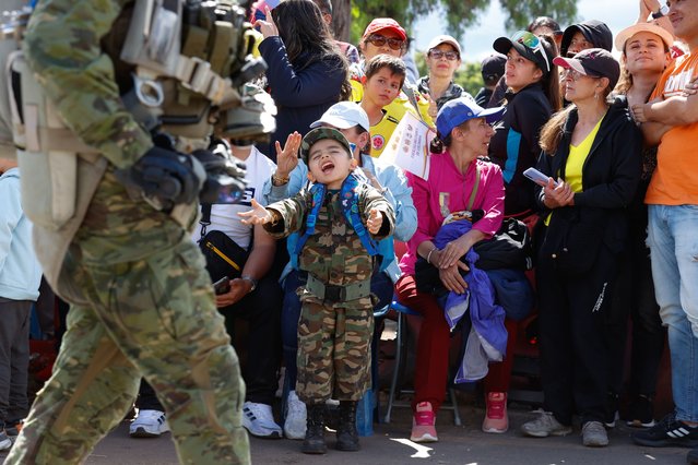 A Colombian child with military clothes greets Members of the Colombian Army during a military parade within celebrations for Independence Day in Bogota on July 20, 2024. (Photo by Juancho Torres/Anadolu via Getty Images)