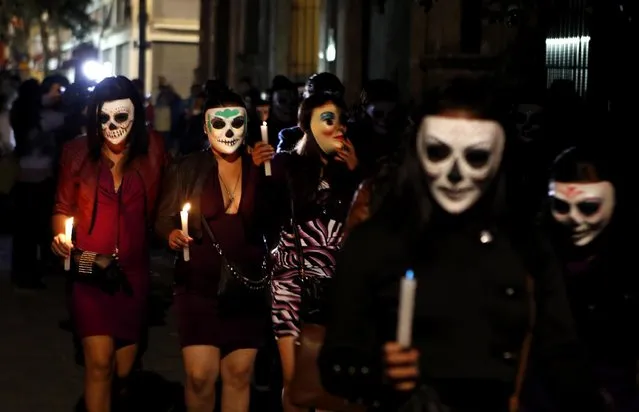 s*x workers, wearing decorative skull masks, march through the streets in downtown Mexico City, Friday, October 28, 2016. The women march with candles to an altar dedicated to their departed colleagues, many who died violently at the hands of their customers. This annual procession, tied to the Day of the Dead festivities, has taken place for more than 20 years. (Photo by Eduardo Verdugo/AP Photo)