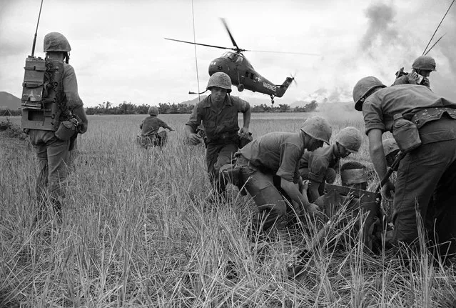 Medics prepare to evacuate Marine Pfc. Robert E. Herbison of Medford, Ore., after he was wounded in the head and legs by Viet Cong sniper fire, May 5, 1965. Herbison was hit during Marine offensive operation against Viet Cong village complex of Le My, southwest of Da Nang, South Vietnam on May 4. (Photo by Eddie Adams/AP Photo)