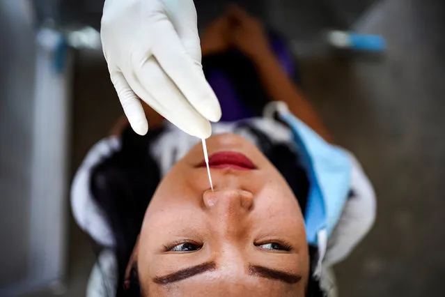 A nose swab test is performed on a local resident of a community in Bangkok, amid the coronavirus disease (COVID-19) outbreak in Thailand, April 28, 2020. (Photo by Athit Perawongmetha/Reuters)