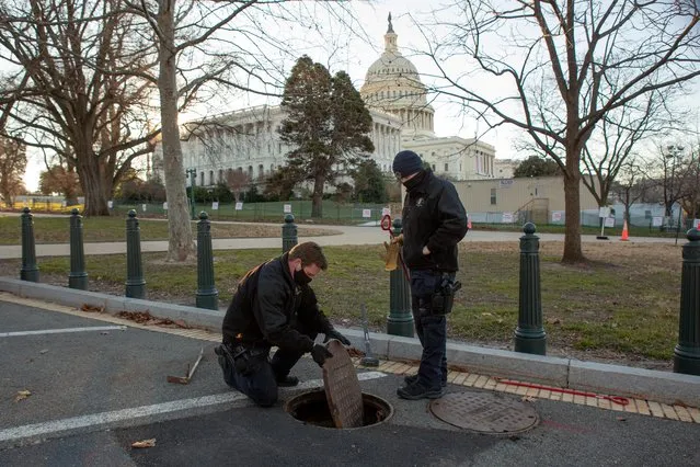 U.S. Capitol Police Officers with the Hazardous Devices Section inspect and seal a manhole on the grounds of the U.S. Capitol building on Capitol Hill in Washington, U.S., January 10, 2021. (Photo by Allison Shelley/Reuters)