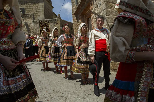 Women wear the traditional costumes of “Lagarteranas” and a man take part on the Corpus Christi procession on June 3, 2018 in Lagartera, in Toledo province, Spain. The Corpus Christi procession of Lagartera throws back to 1590. Before the procession, villagers decorate the streets with embroidered blankets and clothes, and place altars with Baroque carvings of the baby Jesus.  Some blankets have been passed down from generation to generation since XVI century. Women dress in colorful, embroidered, traditional costumes. (Photo by Pablo Blazquez Dominguez/Getty Images)