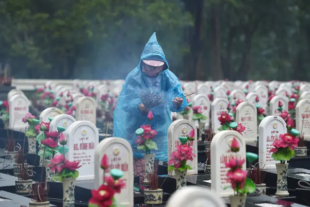 A visitor lights incense sticks at the Truong Son Martyr's Cemetery, where 10,263 Vietnamese war soldiers are laid to rest, in Quang Tri province on December 8, 2020. (Photo by Nhac Nguyen/AFP Photo)