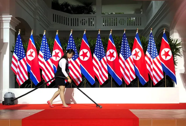 A worker vacuums the stage at the spot where U.S. President Donald Trump and North Korea's leader Kim Jong Un are expected to meet and shake hands for the first time at the start of their summit at the Capella Hotel on Singapore's resort island of Sentosa in Singapore June 12, 2018. (Photo by Jonathan Ernst/Reuters)