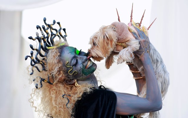 A participant poses with her dog at the Horror Gazebo during the annual West Side Halloween Festival at Lake Mill Island in Bucharest, Romania, 26 October 2024. West Side Hallo Fest is the largest Halloween festival in Romania, held from 25 to 27 October, with approximately 100,000 visitors expected to attend. (Photo by Robert Ghement/EPA/EFE)