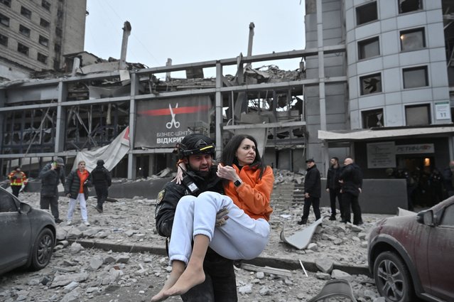 A police officer evacuates a woman from a building heavily damaged by a Russian missile strike, amid Russia's attack on Ukraine, in Zaporizhzhia, Ukraine on December 10, 2024. (Photo by Reuters/Stringer)