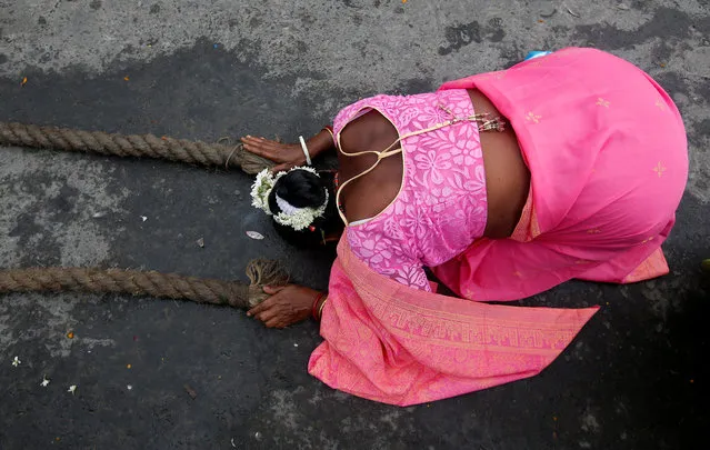 A Hindu woman lies on a road as she touches holy ropes tied to a “Rath”, or the chariot of Lord Jagannath, to seek blessings on the last day of the week-long celebration of Lord Jagannath's “Rath Yatra”, or the chariot procession, in Kolkata, India July 22, 2018. (Photo by Rupak De Chowdhuri/Reuters)