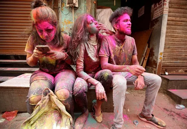 People daubed in colours rest as they take a break during Holi celebrations, amidst the spread of the coronavirus disease (COVID-19), in Chennai, India, March 29, 2021. (Photo by P. Ravikumar/Reuters)