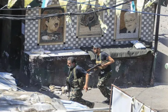 Members of the Palestinian Fatah group run to take position during a third day of clashes that erupted with Islamist factions in the Palestinian refugee camp of Ein el-Hilweh near the southern port city of Sidon, Lebanon, Monday, July 31, 2023. A Lebanese army spokesperson said the death toll from the fighting in Ein el-Hilweh camp had reached six, although some reports have given higher figures. Two soldiers stationed outside the camp were lightly wounded, Col. Fadi Abou Eid said. (Photo by Mohammad Zaatari/AP Photo)