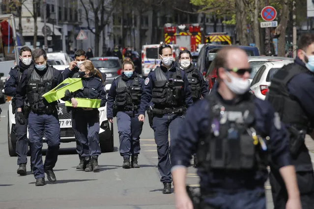 Police officers leave the scene after a shooting Monday, April 12, 2021 in Paris. A gunman has shot two people in front of a hospital in Paris and the attacker fled on a motorcycle. (Photo by Christophe Ena/AP Photo)
