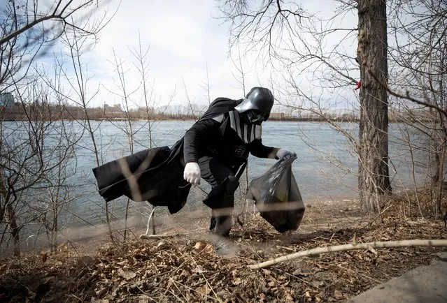A volunteer dressed as the Star Wars character Darth Vader picks up trash during a street cleaning event marking the 60th anniversary of the first manned space flight in Irkutsk, Russia on April 12, 2021. (Photo by Yuri Novikov/Reuters)