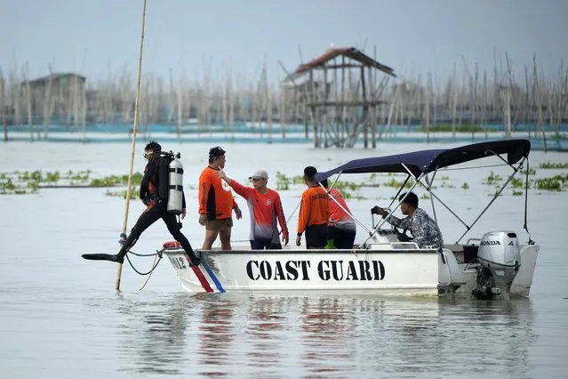 Rescuers search for victims of a capsized passenger boat in Rizal, Philippines, Friday, July 28, 2023. A ferry turned upside down when passengers suddenly crowded to one side in panic as fierce winds pummeled the wooden vessel, killing a number of people, officials said Friday. (Photo by Aaron Favila/AP Photo)