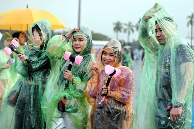 Fans wear colorful rain covers as they wait in the rain at the My Dinh National Stadium stadium for the start of a concert of the South Korean K-Pop girl group “Blackpink”, in Hanoi, Vietnam, 29 July 2023. The South Korean girl group will perform on 29 and 30 July at the city's My Dinh National Stadium on their last stop in Asia of their “Born Pink” World Tour. (Photo by Luong Thai Linh/EPA)