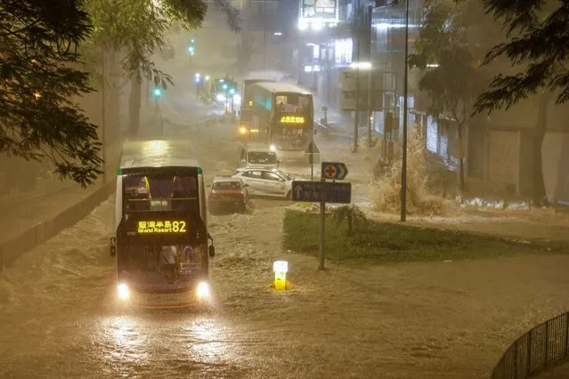 A bus drives past a flooded area during heavy rain, in Hong Kong, China on September 8, 2023. (Photo by Tyrone Siu/Reuters)