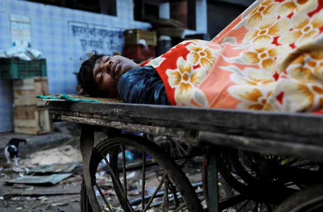 A man sleeps on a hand cart at a slum in Mumbai, India, October 3, 2018. (Photo by Danish Siddiqui/Reuters)
