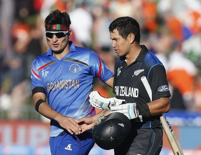 New Zealand's Ross Taylor gets a handshake from Afghanistan;s Hamid Hassan (L) after their Cricket World Cup match in Napier, March 8, 2015. REUTERS/Nigel Marple (NEW ZEALAND - Tags: SPORT CRICKET)