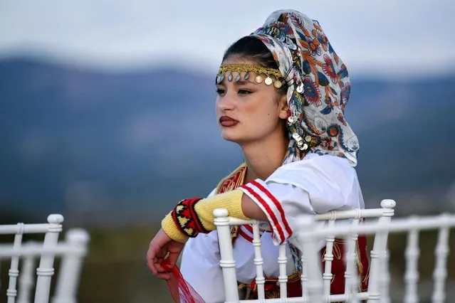 A girl dressed in a traditional costume waits for her performance to start during the Ulpiana Festival held at the archeological site of Ulpiana, near Pristina on September 17, 2023. (Photo by Armend Nimani/AFP Photo)