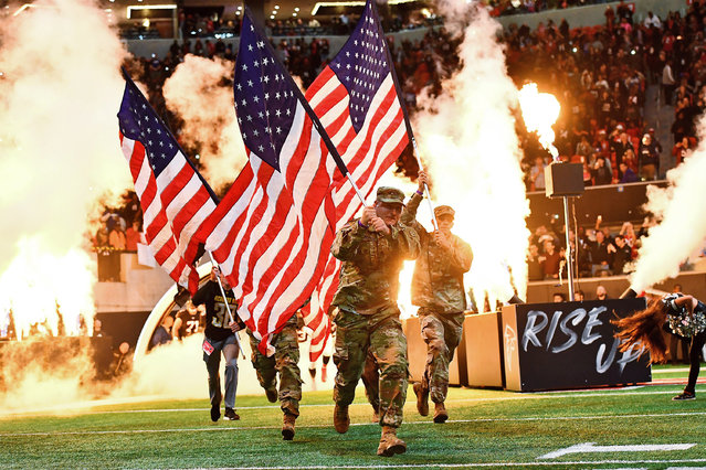 Military troops run out for the national anthem out before the start of the first quarter against the New York Giants at Mercedes-Benz Stadium on October 22, 2018 in Atlanta, Georgia. (Photo by Scott Cunningham/Getty Images)