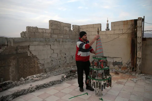 Akram Abu al-Foz, decorates a christmas tree from empty shells he collected and drew on, in the rebel held besieged city of Douma, in the eastern Damascus suburb of Ghouta, Syria December 23, 2016. (Photo by Bassam Khabieh/Reuters)