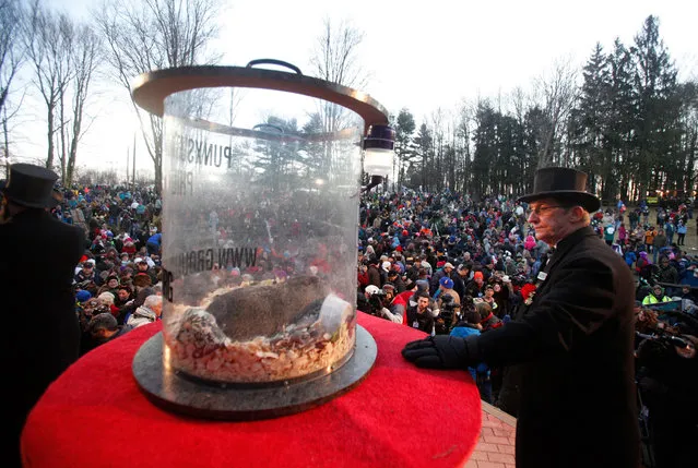 Groundhog club co-handler Ron Ploucha looks at Punxsutawney Phil on display above the crowd during the Groundhog Day celebration at Gobblers Knob in Punxsutawney, Pennsylvania, USA, 02 February 2016. (Photo by David Maxwell/EPA)