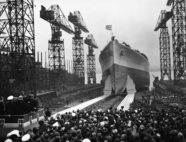 HMS Prince of Wales, a King George V class 35,000 tonne battleship is launched in front of vast crowds, by Princess Mary, The Princess Royal, unseen, on the River Mersey at Birkenhead, England, on May 3, 1939. 40,000 people cheered as she slipped into the water after a faultless launch. She is to be the world’s fastest battleship, with a speed of over 30 knots. Her horse power and speed are confidential and no figures are being issued. She carried ten fourteen inch guns in three turrets and a secondary armament of sixteen 5-¼ inch guns. (Photo by AP Photo/Staff/Puttnam)