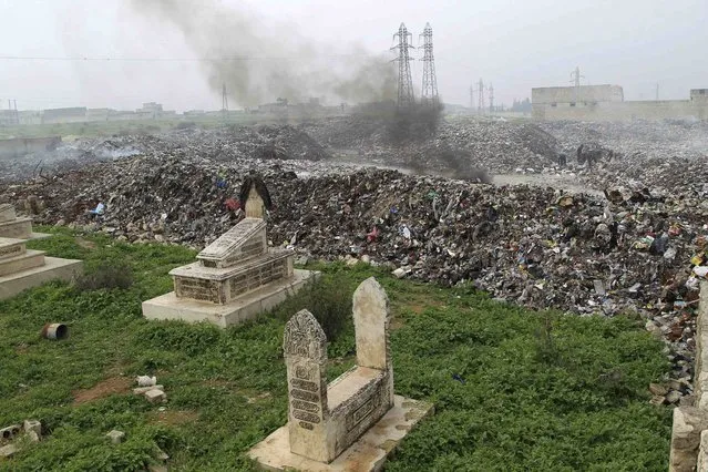 Graves are seen beside a rubbish dump while Scavengers sift through garbage in Aleppo January 21, 2015. (Photo by Jalal Al-Mamo/Reuters)