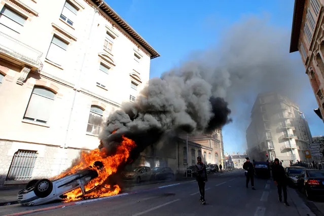 A burning car is seen in the street as youths and high-school students clash with police during a demonstration against the French government's reform plan in Marseille, France, December 6, 2018. (Photo by Jean-Paul Pelissier/Reuters)