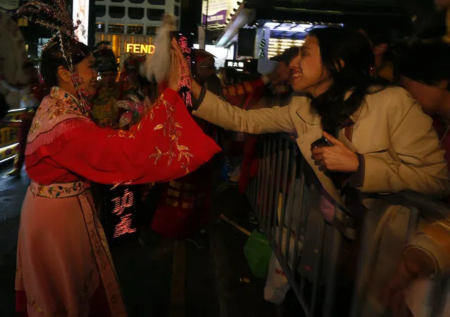 A spectator greets a Chinese dance performer during a Lunar New Year parade celebrating the first day of the Lunar New Year of the Monkey in Hong Kong, China February 8, 2016. (Photo by Bobby Yip/Reuters)