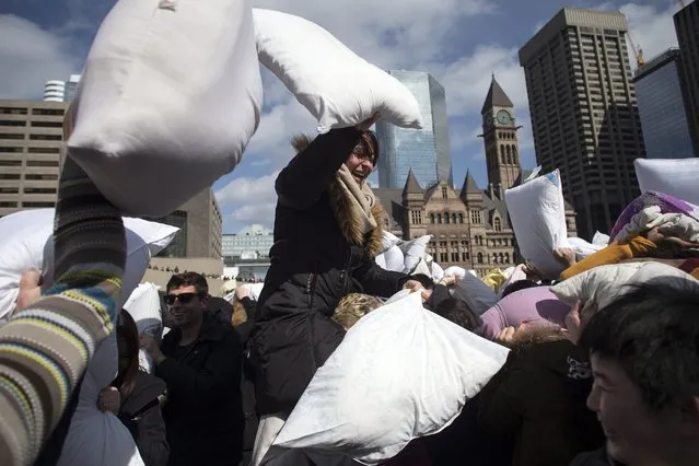 People participate in a pillow fight to mark International Pillow Fight Day, Saturday, April 4, 2015, in Toronto. (Photo by Chris Young/AP Photo/The Canadian Press)