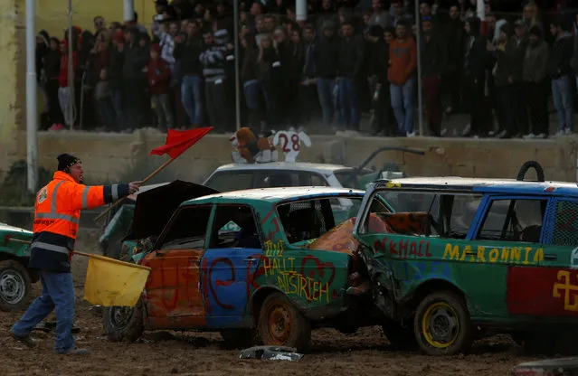 A marshall tries to attract a driver's attention during a demolition derby organised by the Malta Motor Sports Association to raise funds for charity in Ta' Qali, outside Valletta, Malta, January 8, 2017. (Photo by Darrin Zammit Lupi/Reuters)