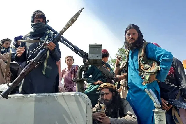 Taliban fighters sit over a vehicle on a street in Laghman province on August 15, 2021. (Photo by AFP Photo/Stringer Network)