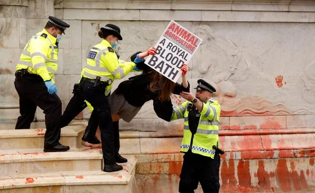 Police officers detain an Extinction Rebellion activist during a protest next to Buckingham Palace in London, Britain, August 26, 2021. (Photo by John Sibley/Reuters)