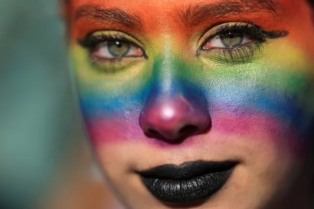 A woman with a rainbow-colored mark on her face smiles during the Pride March, organized by the Lesbian, Gay, Bisеxual, Transgender, and Queer (LGBTQ) community, in Buenos Aires, Argentina on Saturday, November 5, 2022. (Photo by Tomas Cuesta/Reuters)