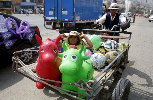 A seller of toys pushes a cart on a street in Comas on the outskirts of Lima, March 4, 2016. (Photo by Mariana Bazo/Reuters)