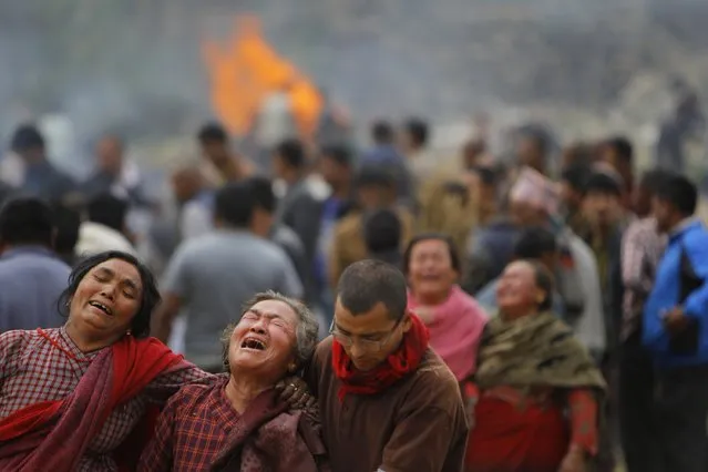 Family members break down during the cremation of earthquake victims in Bhaktapur near Kathmandu, Nepal, Sunday, April 26, 2015. (Photo by Niranjan Shrestha/AP Photo)