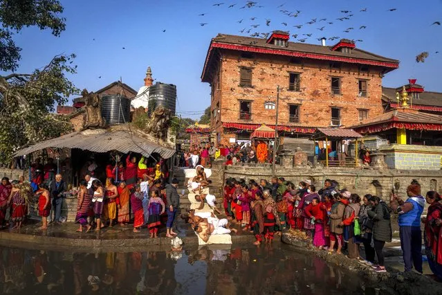 Hindu devotees perform rituals by the Hanumante river during Madhav Narayan festival in Bhaktapur, Nepal, Thursday, January 25, 2024. (Photo by Niranjan Shrestha/AP Photo)
