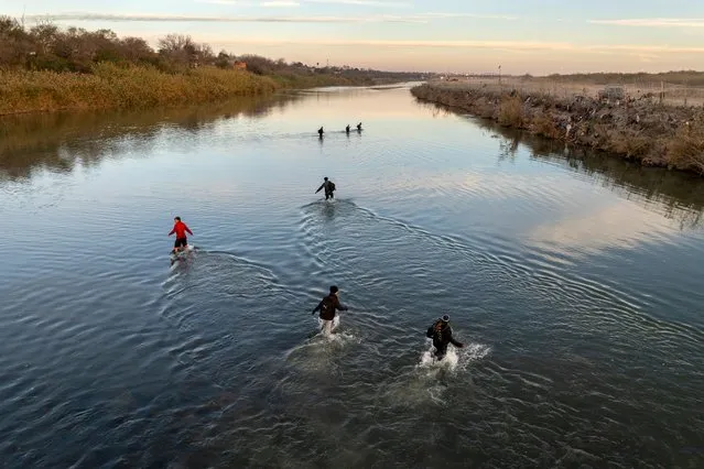 In an aerial view, immigrants wade across the Rio Grande while crossing from Mexico into the United States on January 07, 2024 in Eagle Pass, Texas. According the a new report released by U.S. Department of Homeland Security, some 2.3 million migrants, mostly from families seeking asylum, have been released into the U.S. under the Biden Administration since 2021. (Photo by John Moore/Getty Images)