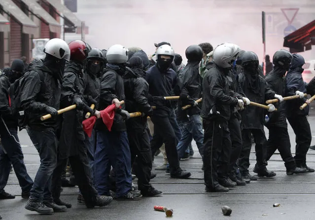 Masked demonstrators march during a protest against the Expo 2015 fair in Milan, Italy, Friday, May 1, 2015. Dozens of people are protesting the opening of Milan's Expo 2015, torching parked cars, smashing bank and store windows and clashing with riot police far from the world's fair sprawling grounds. (Photo by Riccardo De Luca/AP Photo)