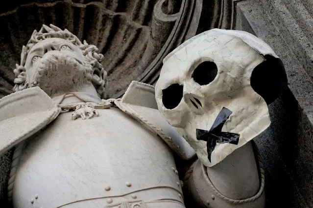A view of one of several papier-mache skulls with an “X” made with black adhesive tape, placed by unknown people in the night over numerous statues of the city center of Naples, southern Italy, 19 October 2021. The night raid was not claimed by anyone. (Photo by Ciro Fusco/EPA/EFE)