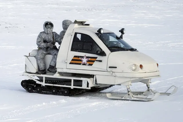 In this photo taken on Wednesday, April 3, 2019, a Russian military snowmobile moves on Kotelny Island , part of the New Siberian Islands archipelago located between the Laptev Sea and the East Siberian Sea, Russia. (Photo by Vladimir Isachenkov/AP Photo)