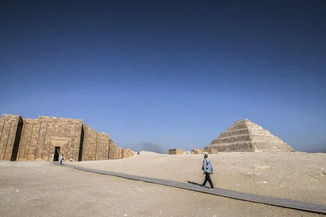 A security guard in civilian clothing carrying an assault rifle walks near the step pyramid of the third dynasty Ancient Egyptian Pharaoh Djoser (27th century BC) at the Saqqara Necropolis south of Egypt's capital Cairo on September 14, 2021. (Photo by Khaled Desouki/AFP Photo)