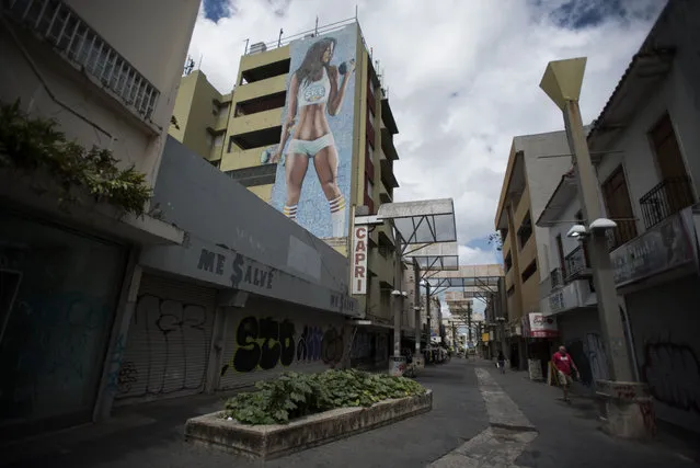 Shops are shuttered in the Paseo de Diego in San Juan, Puerto Rico, Wednesday, April 17, 2019. This central thoroughfare in Rio Piedras was filled years ago with stores that are closed and empty today. (Photo by Carlos Giusti/AP Photo)