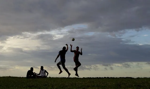 Young men play a game of rugby at sunset in Nuku'alofa, Tonga, Wednesday, April 10, 2019. The island nation of Tonga has reported its first-ever case of COVID-19, Friday Oct. 29, 2021 after a traveler from New Zealand tested positive. (Photo by Mark Baker/AP Photo/File)