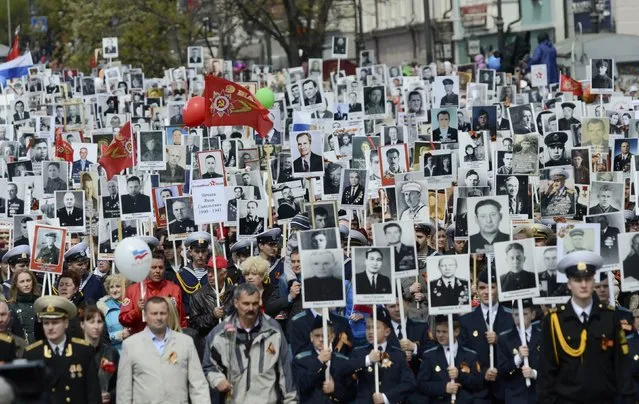 People hold pictures of World War Two soldiers as they take part in the Immortal Regiment march during the Victory Day parade in Vladivostok, Russia, May 9, 2015. (Photo by Yuri Maltsev/Reuters)