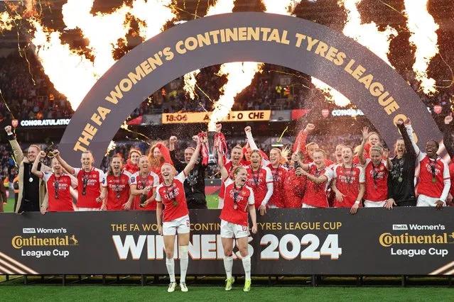 Arsenal's English defender #06 Leah Williamson (centre left) and Arsenal's Scottish midfielder #10 Kim Little (centre right) hold the trophy as Arsenal's players celebrate their win after the English Women's League Cup final football match between Arsenal and Chelsea at Molineux in Wolverhampton, central England on March 31, 2024. Arsenal won the game 1-0 after extra time. (Photo by Adrian Dennis/AFP Photo)
