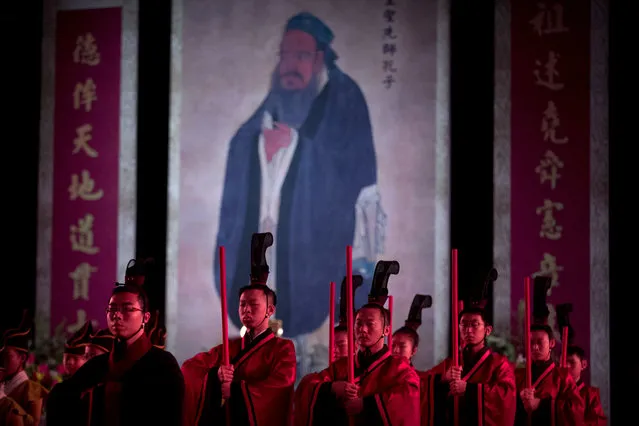 In this Sept. 28, 2016 file photo, participants in traditional dress stand near an oversized portrait of Confucius during a ceremony to observe the 2567th anniversary of his birth in Beijing. A Chinese government department announced on Monday, May 27, 2019, that China is running five-day Confucian culture immersion courses for religious leaders in the sage's hometown as part of a campaign to extend government control over faith communities through a process of sinicization. (Photo by Mark Schiefelbein/AP Photo/File)