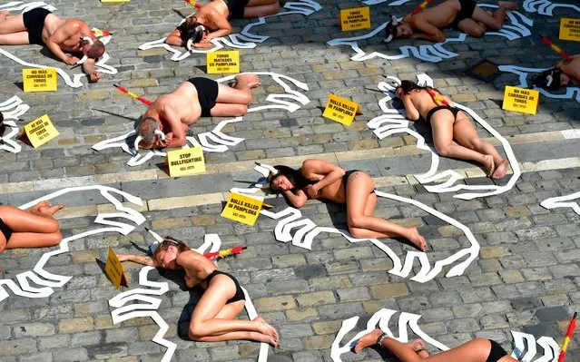 Pro-animal rights activists lie on the ground during a protest against bullfighting and bull-running called by the People for the Ethical Treatment of Animals (PETA) pro-animal group on the eve of the San Fermin festivities in the Northern Spanish city of Pamplona on July 5, 2019. (Photo by Ander Gillenea/AFP Photo)