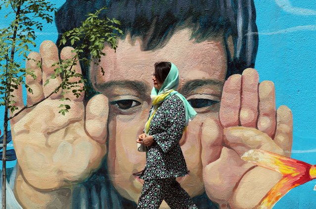 A woman walks past a wall painting of a child in Tehran, Iran, 25 April 2024. Tension between Iran and Israel continues since Iran's Islamic Revolutionary Guards Corps (IRGC) launched drones and missiles towards Israel on 13 April 2024, following an airstrike on the Iranian embassy in Syria, which Iran claimed was conducted by Israel. Iranian state media reported that three aerial objects were destroyed by air defense systems over the central city of Isfahan in the early morning of 19 April 2024. (Photo by Abedin Taherkenareh/EPA/EFE)