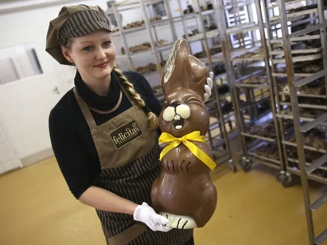 Employee Sandra Jaeckel carries a giant chocolate Easter bunny through the production facility at Confiserie Felicitas chocolates maker in Hornow. (Photo by Sean Gallup/Getty Images)