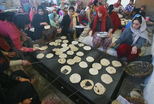 Devotees prepare “roti” (Indian bread) at a community kitchen in a Gurudwara or a Sikh temple on the occasion of the birth anniversary of Guru Gobind Singh, the last and the tenth Guru of the Sikhs, in the northern Indian city of Chandigarh January 11, 2011. (Photo by Ajay Verma/Reuters)